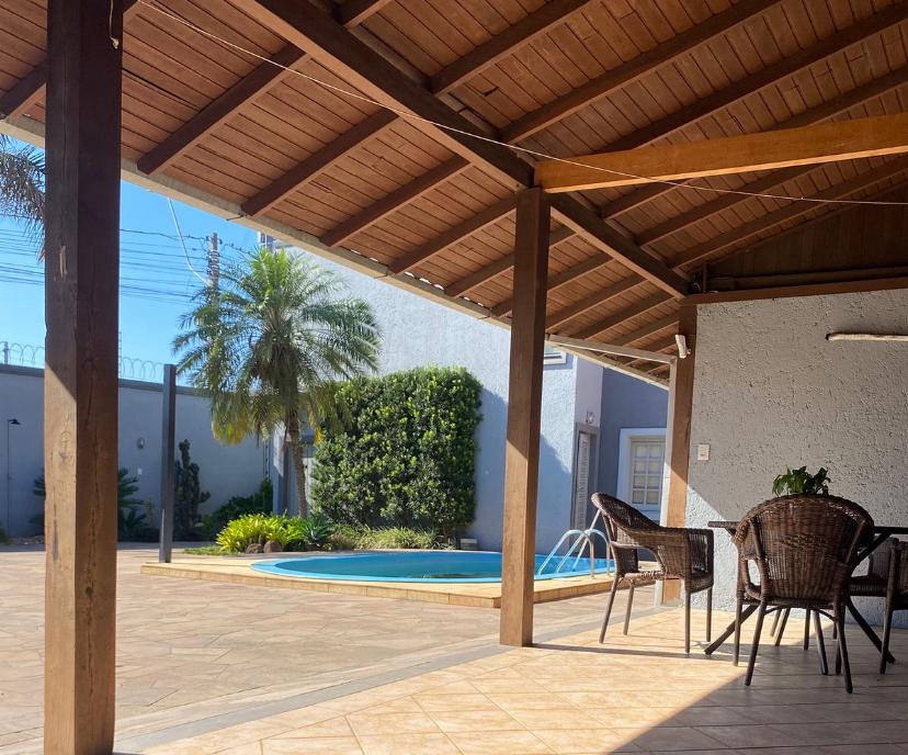 Área externa coberta com mesas e piscina